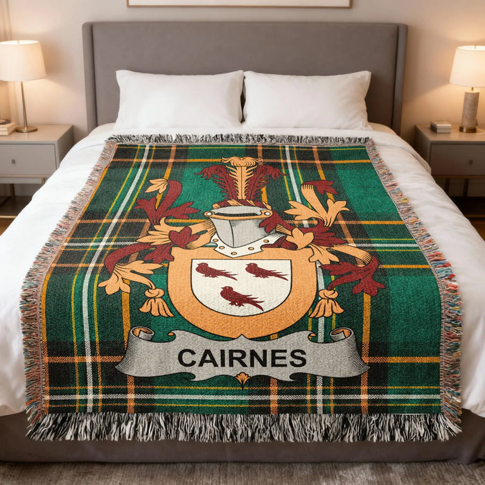 Cairnes family crest woven blanket laid across a bed.