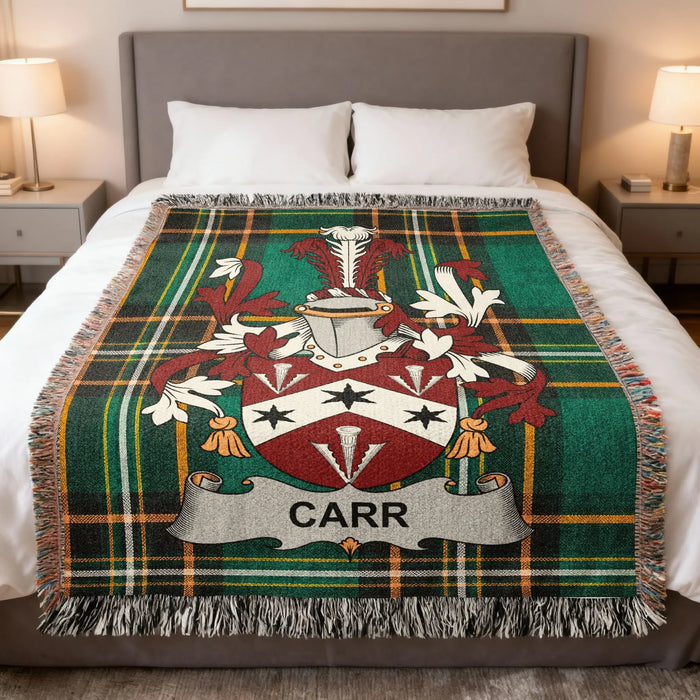 Carr family crest woven blanket laid across a bed.