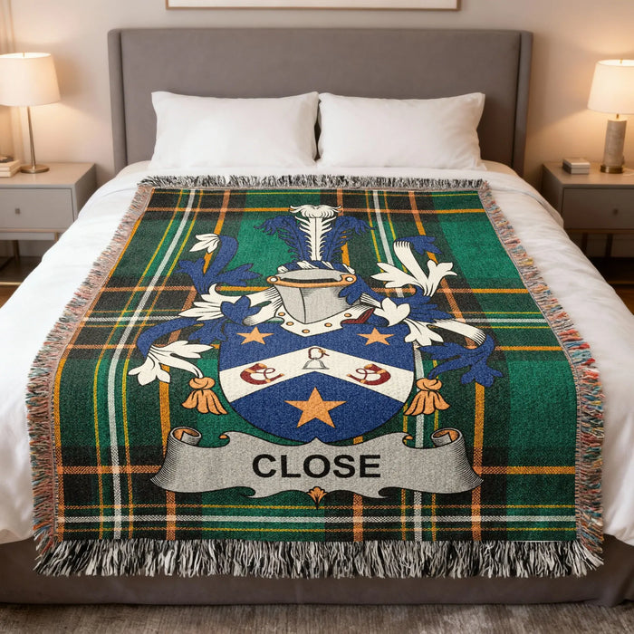 Close family crest woven blanket laid across a bed.