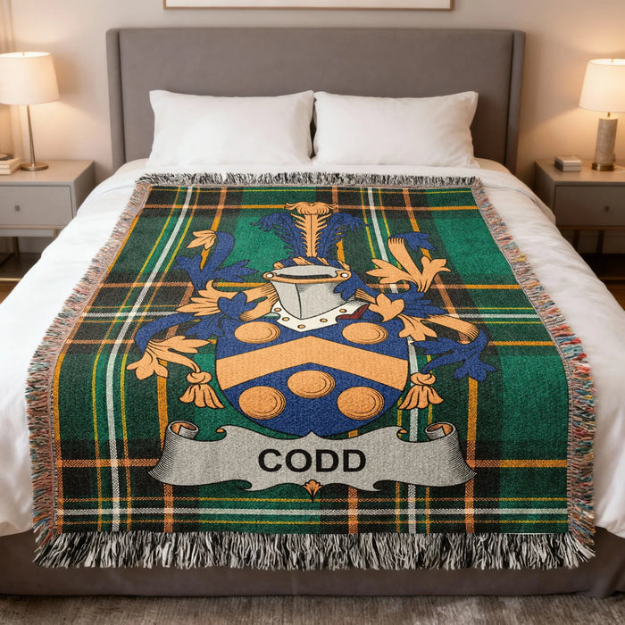 Codd family crest woven blanket laid across a bed.