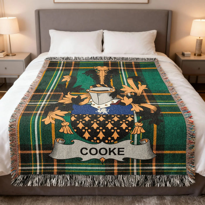 Cooke family crest woven blanket laid across a bed.