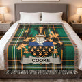 Cooke family crest woven blanket laid across a bed.