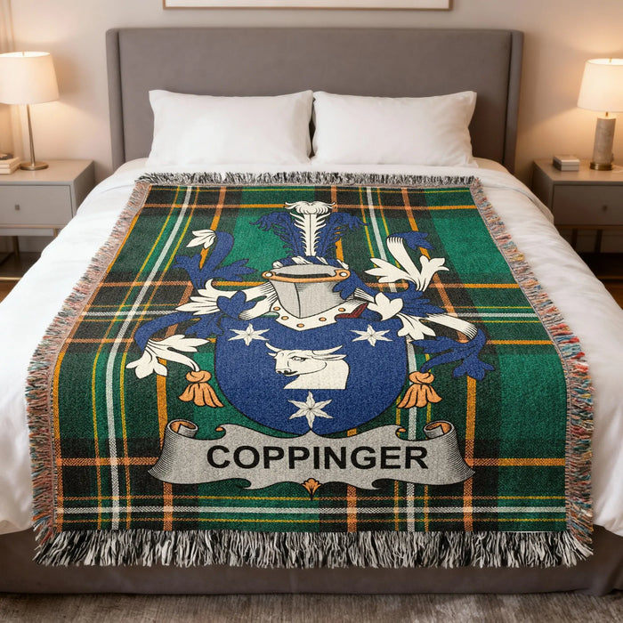 Coppinger family crest woven blanket spread across a bed.