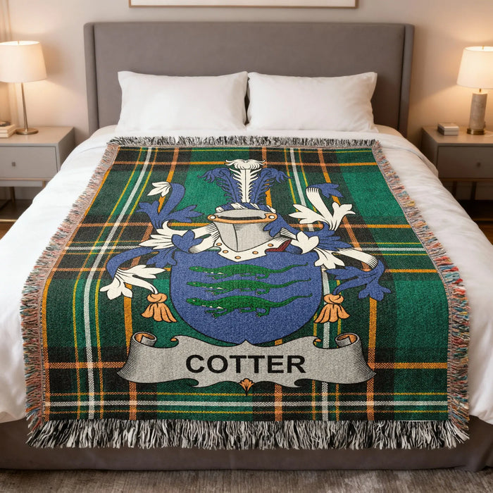 Cotter family crest woven blanket laid across a bed.