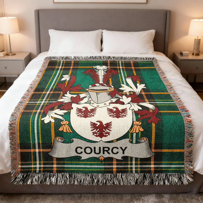 Courcy family crest woven blanket spread over a bed.