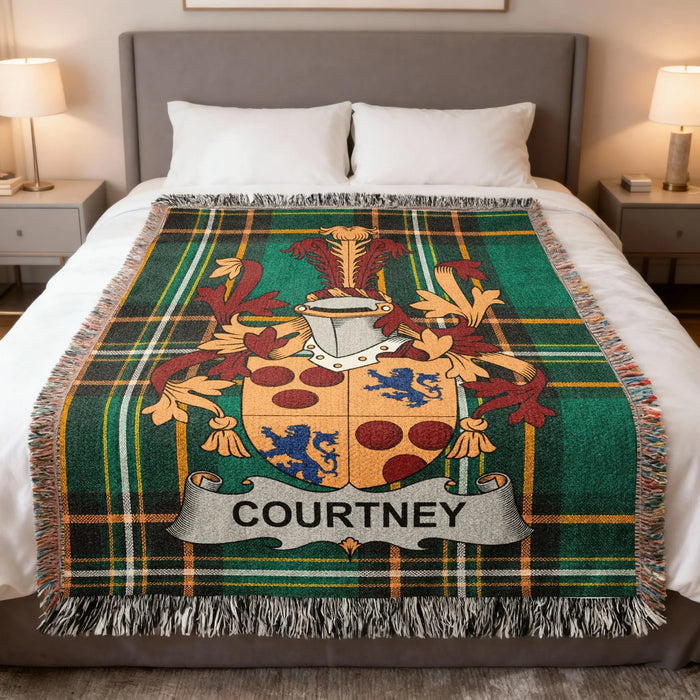 Courtney family crest woven blanket laid across a bed.