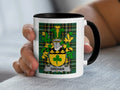 White mug with black rim featuring a green plaid crest with the name GREHAN.