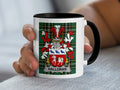 White mug with black handle featuring Halloran family crest on plaid background.