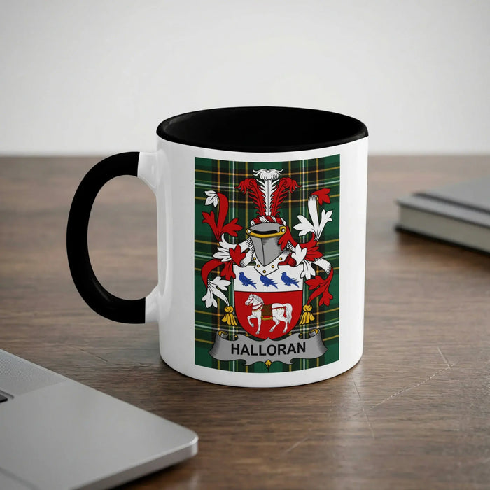 White mug with black rim and handle displaying a Halloran family crest on a green plaid background.