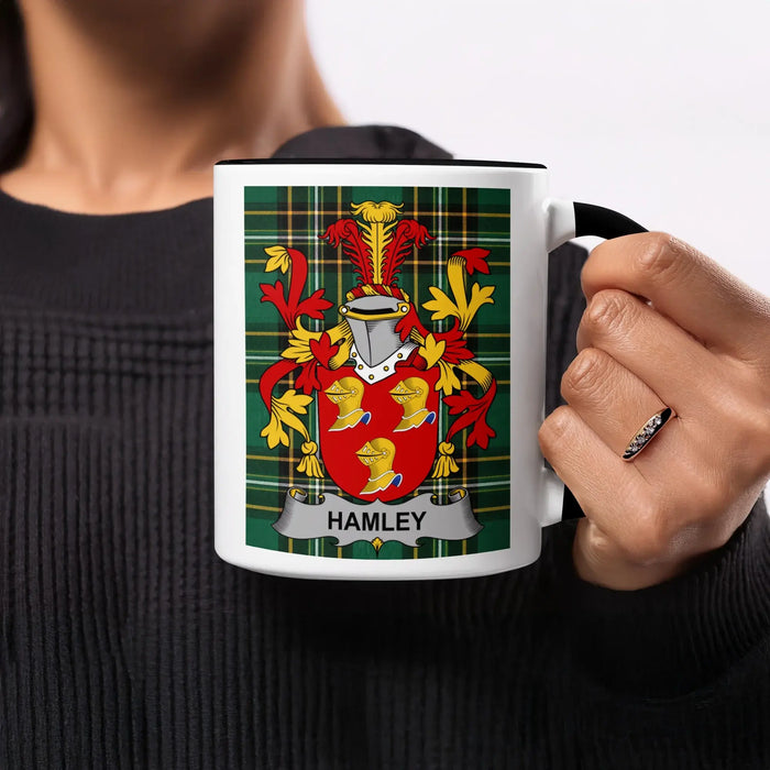 Black mug with white interior displaying a Hamley family crest on a plaid background.