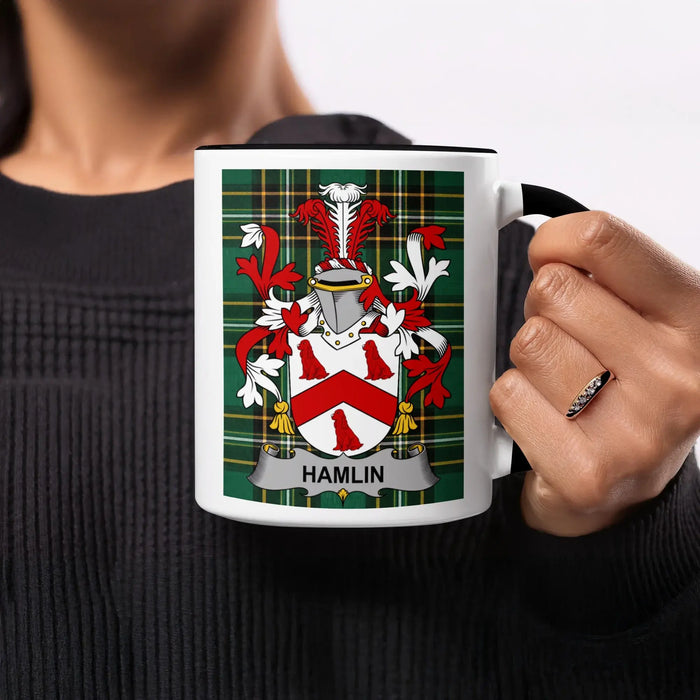 White mug with black handle featuring a Hamlin family crest on a green plaid background.