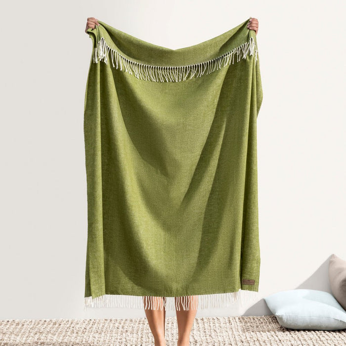 Italian Herringbone Fern Throw by Lands Downunder - Holding throw with fringe visible